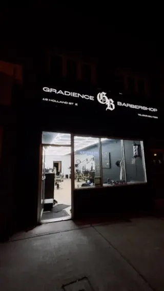 Gradience Barbershop shopfront at night.