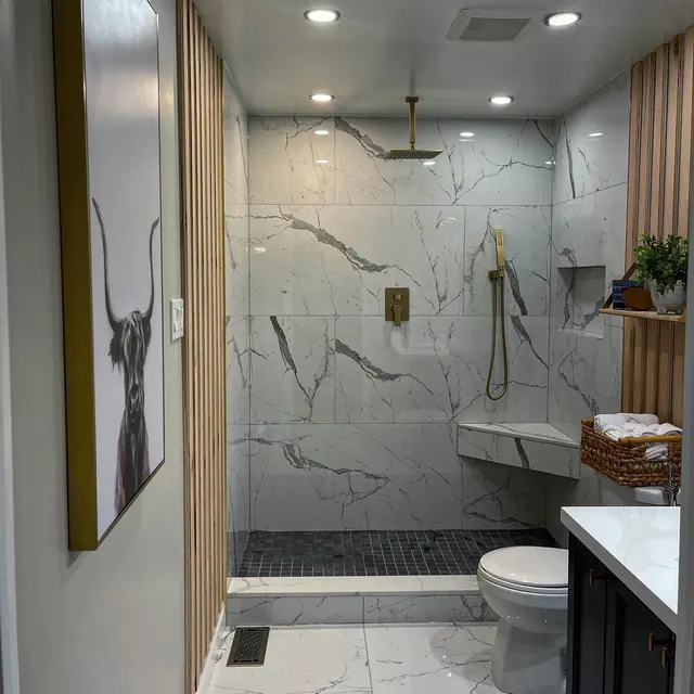Marble walk-in shower with black tapware.