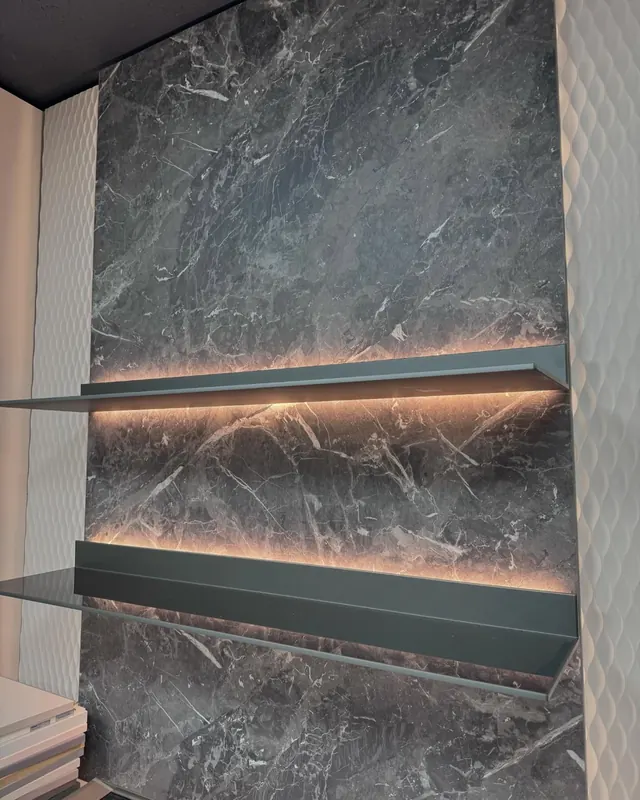 Stone fireplace wall with illuminated floating shelves.