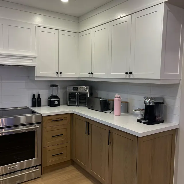 Kitchen in oak and white with a stone worktop.
